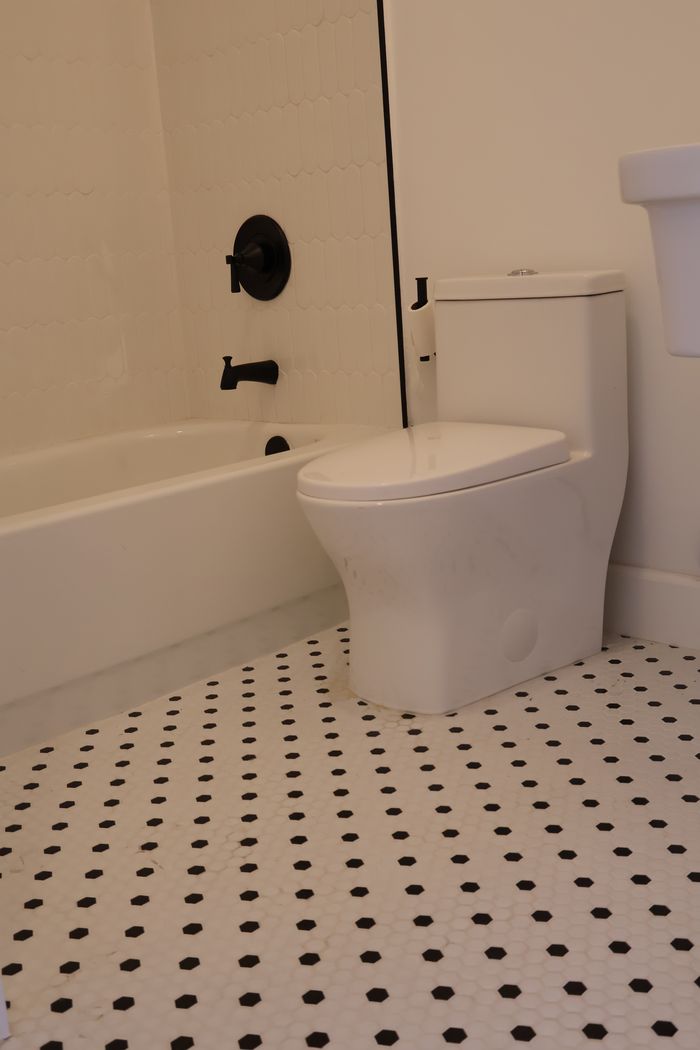 Bathroom remodel with classic black and white hex tile floor