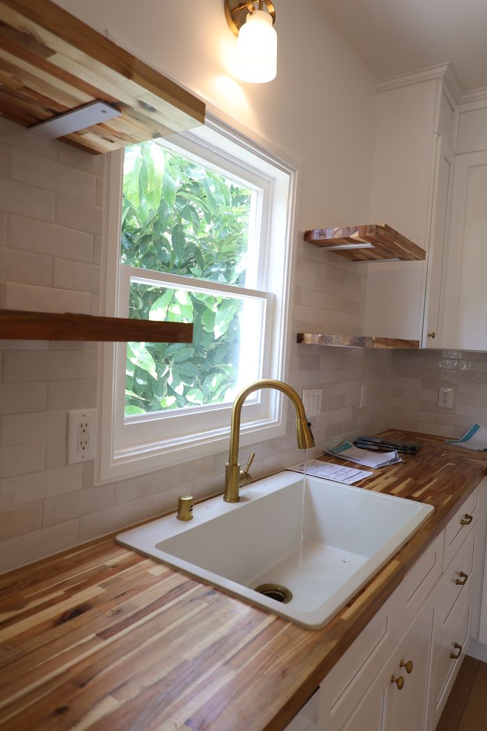 Butcher block counters, brass faucet and farmhouse sink detail