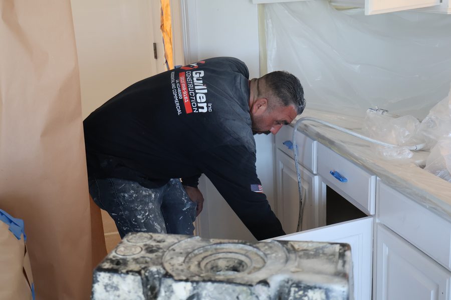 Guillen crew member prepping cabinets during a kitchen refresh